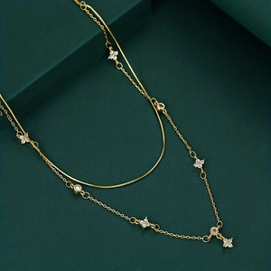 Detail of double-layer gold necklace featuring lucky four-leaf clover and zircon accents