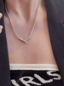 Detail of silver snake chain necklace with unique irregular hook clasp on a model