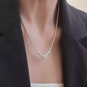 Silver snake chain necklace with unique hook clasp worn by model over a black blazer
