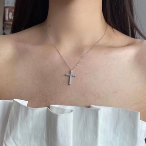 Gros plan d'un collier pendentif croix étincelant avec cristaux sur chaîne argentée