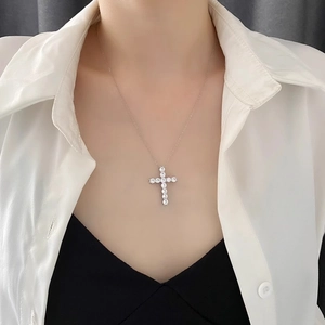 Collier croix argenté avec zircons cubiques porté par un mannequin sur chemise blanche