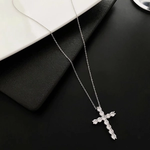 Élégant collier croix en argent avec diamants pavés sur fond minimaliste noir et blanc