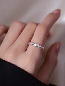 Detail of Korean style matte silver ring with pink flower stones and star engravings