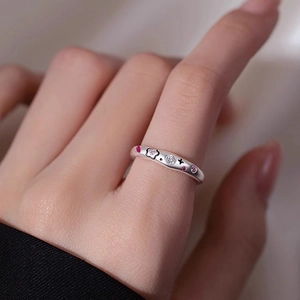 Floral silver ring with pink zircon and star carvings shown on finger