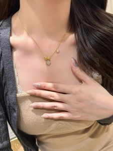 Détail d'un élégant collier trèfle doré avec diamants étincelants porté par un modèle