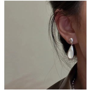 Detailed view of minimalist teardrop earrings with moonstone on model
