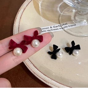 Detail of red and black velvet bow earrings with pearls for elegant women's jewelry