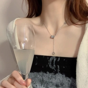 Dettaglio della collana d'argento con cilindro pavé e ciondolo ad anello indossata