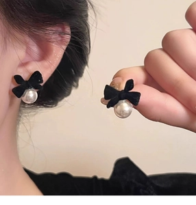 Detail of French vintage black velvet bow earrings with white pearl pendants
