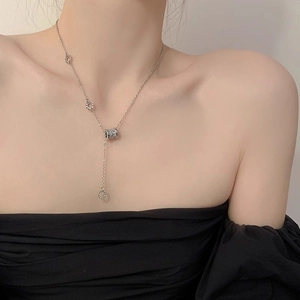 Dettaglio della collana a Y argento con ciondoli in strass pavé e anelli eleganti