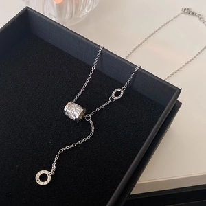Dettaglio collana argento con anelli a numeri romani e pendente con pavé di cristalli