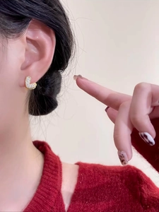 Gros plan de boucles d'oreilles cœur en or serties de zircons blancs sur un mannequin