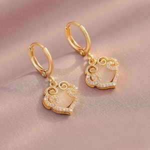 Elegant gold heart earrings with opal gemstone and hollow swirls on silk background