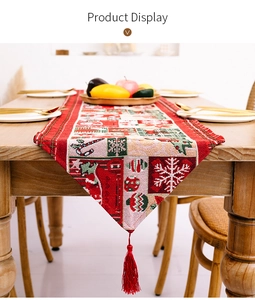 Detail eines Weihnachts-Tischläufers mit Schneeflockenmustern und roten Quasten-Details