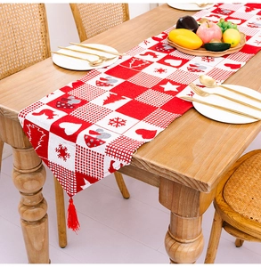 Nahaufnahme eines Weihnachts-Tischläufers mit Rentier-Motiven und roten Quasten