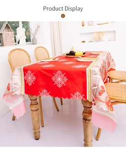 Detail of red Christmas tablecloth with white snowflakes and scalloped edges for festive decor