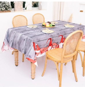 Detail of waterproof Christmas gnome tablecloth with grey wood grain and wavy edges
