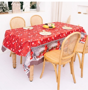 Detail of red Christmas tablecloth featuring Nordic gnomes, snowflakes and wavy edge design
