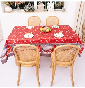 Macro view of red Christmas tablecloth featuring scalloped edges and festive gnome prints