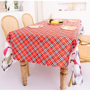 Detail of red plaid Christmas tablecloth with gnome prints and scalloped edge design