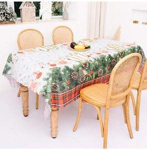 Detail of Christmas tablecloth with pine cones, red berries and Merry Christmas print
