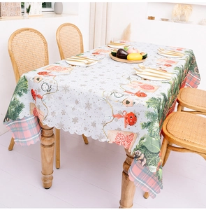 Detailed view of Christmas tablecloth with pine branches, bells and scalloped edges
