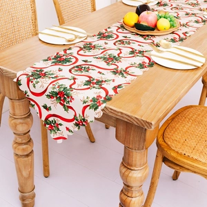 Christmas table runner with red ribbon and holly berry print on scalloped edge fabric