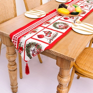 Weihnachtlicher Tischläufer mit roten und weißen Kranzmustern und dekorativen Quasten