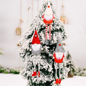 Three-piece Christmas forest gnome set with long legs hanging on a snowy holiday tree