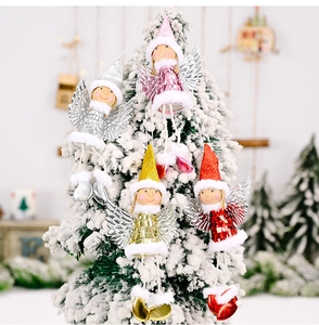 Detail of sequined Christmas angel ornaments with wings on a snowy tree