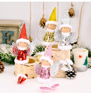 Detail of Christmas angel figurines with sequin outfits and silver wings on birch wood