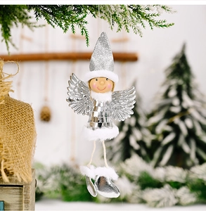 Close-up of a silver sequined Christmas angel ornament hanging on a snowy pine branch