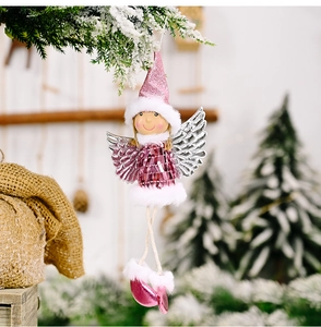 Close-up of pink sequin Christmas angel ornament hanging on a snowy branch