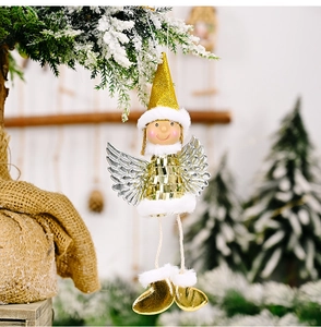Close-up of a sparkling gold sequin Christmas angel ornament hanging on a snowy tree branch