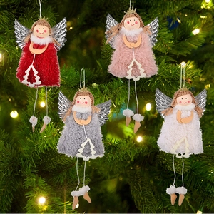 Nahaufnahme von vier Plüsch-Weihnachtsengeln mit silbernen Flügeln am beleuchteten Baum