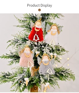 Details von vier farbigen Weihnachtsengel-Puppen mit Silberflügeln am verschneiten Baum