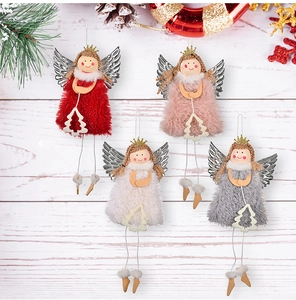 Nahaufnahme von Plüsch-Weihnachtsengeln mit silbernen Flügeln und Holzbaumanhängern