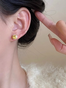 Close-up of elegant square yellow crystal earrings with pavé diamond halo on model