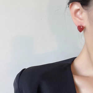 Boucles d'oreilles vintage en émail rouge vin avec bordure dorée portées par un mannequin
