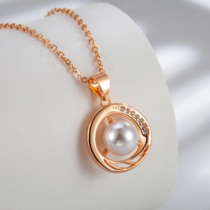 Macro shot of an elegant pearl pendant with rose gold spiral rings and pavé zircon details
