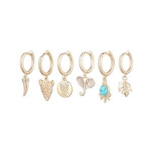 Detailed close-up of 6-piece golden earring set with animal and leaf charms on white back