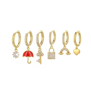 Detail of 6-piece gold hoop earrings featuring rainbow, heart, key and lock charms