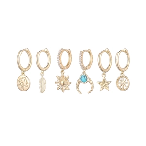 Detail of 6-piece gold earring set with sun, moon, star, feather and coin pendants