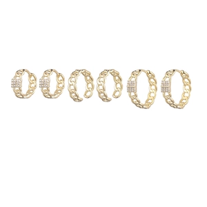 Detail of six-piece gold chain earrings set including zircon hoops and ear cuffs