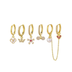 Detail of 6-piece gold earring set with white enamel, pearls, and red gemstones