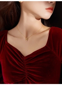 Détail d'un collier pendentif sapin de Noël doré et boucles d'oreilles sur mannequin