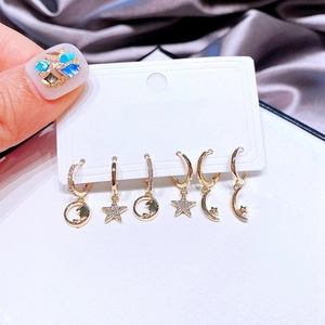 Detailed set of six gold star and moon hoop earrings with zircon on a display card