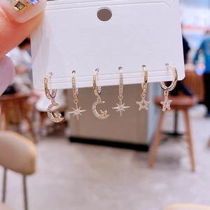 Detail of 6-piece gold moon and star earring set with sparkling crystals and angel charms