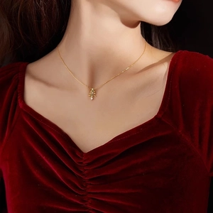 Collier vintage sapin de Noël doré avec détails verts et diamant porté par un mannequin