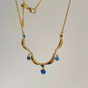Detail of vintage gold tassel necklace featuring blue teardrop stones and adjustable clasp